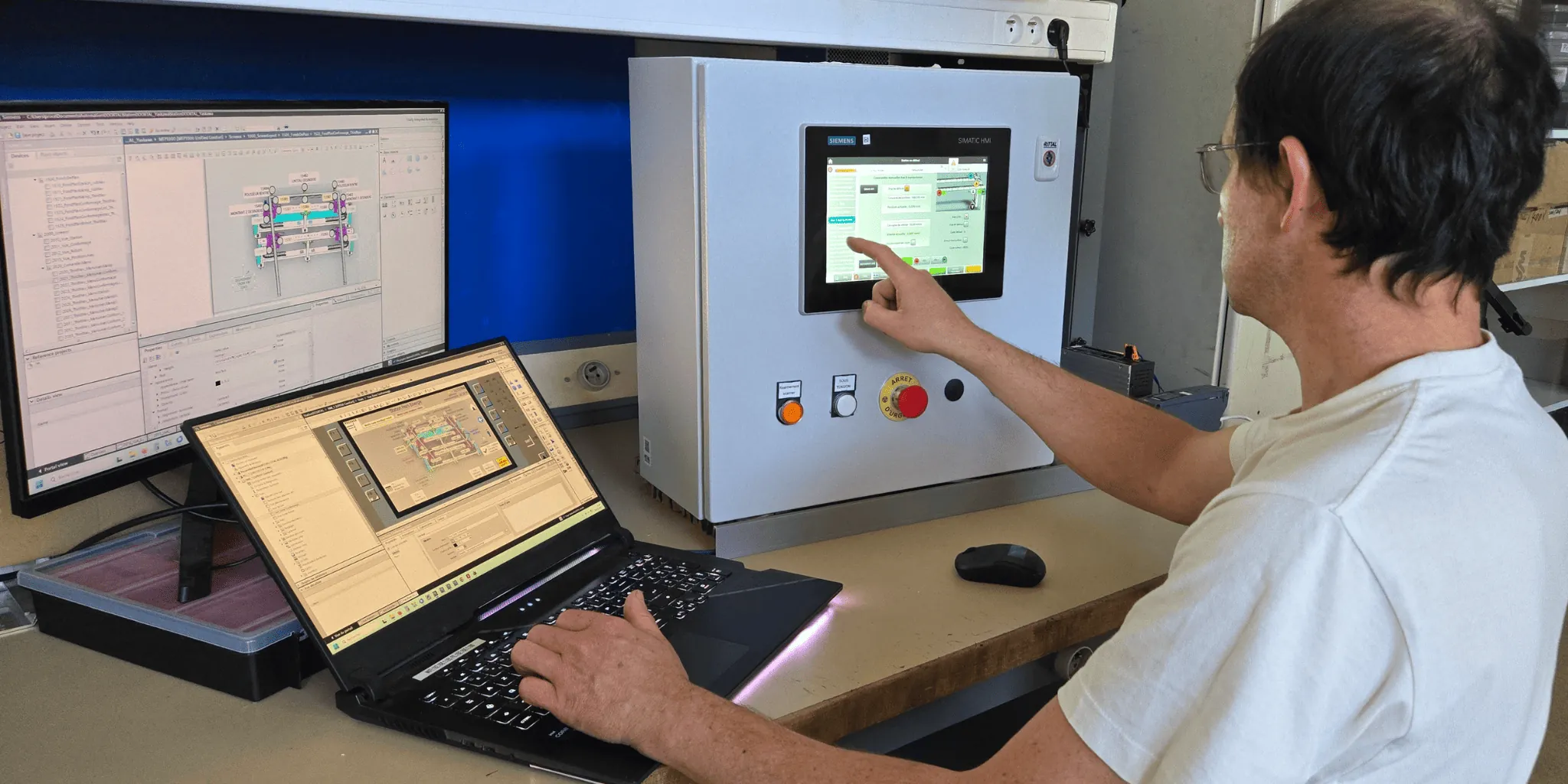 Automaticien programmant une interface homme-machine Siemens sur ordinateur portable.